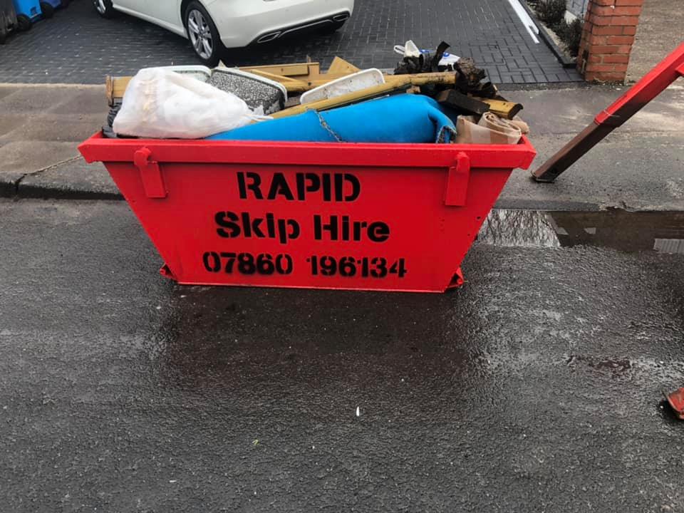 3 red skips stacked on top of eachother reading RAPID skip hire